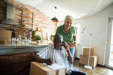 Senior couple moving into new home and unpacking boxes