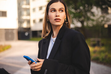 Business short hair woman wear jacket suit, standing outdoor near office, looking, waiting or...