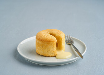 Vanilla chocolate fondant or lava cake dessert in a plate, on a light blue background. Copy space, closeup view.