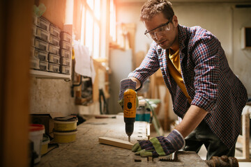 Young carpenter working in his woodworking workshop