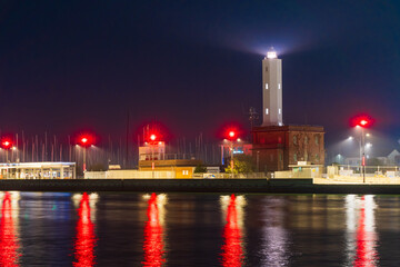 Scena serale con il faro di Marina di Ravenna illuminato sul canale