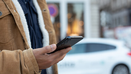 Man using smartphone app for renting electric car sharing service