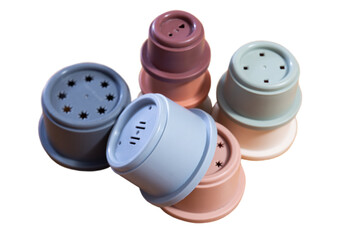 Pastel colored plastic cups from disassembled pyramids arranged, ideal for children play and learning activities. Isolated over white background