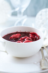 Traditional Christmas Borscht (Barszcz) with mushroom dumplings on bright background.
