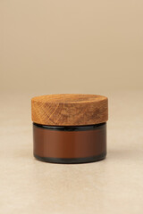 Brown glass jars for cosmetics on beige background