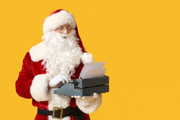 Santa Claus with vintage typewriter on yellow background