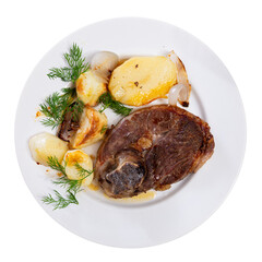Delicious roasted leg of lamb with potatoes and onions served on platter. Isolated over white background