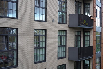 Modern apartment building exterior featuring large windows and balconies in a quiet neighborhood during the late afternoon. Kalamaja, Tallinn, Estonia, Europe