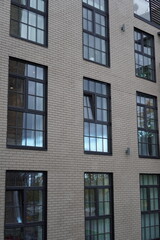 Modern building facade with large windows reflecting the sky in an urban setting during daylight...