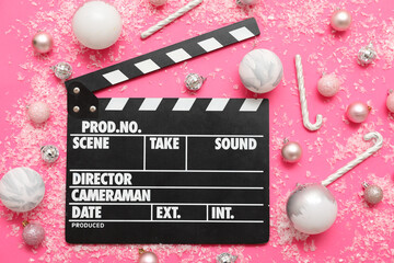 Composition with movie clapper and Christmas decorations on pink background. Top view
