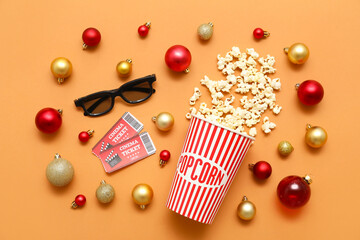 Composition with 3D glasses, bucket of popcorn, cinema tickets and Christmas decorations on orange background. Top view © Pixel-Shot