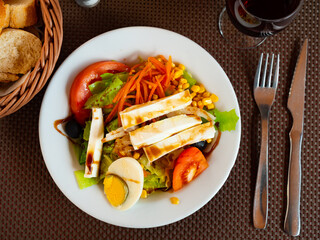 Appetizing salad of fresh vegetables served with tomatoes cheese and eggs on platter