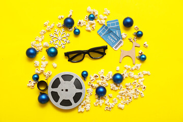 Composition with 3D glasses, cinema tickets, film reel and Christmas decorations on yellow background. Top view