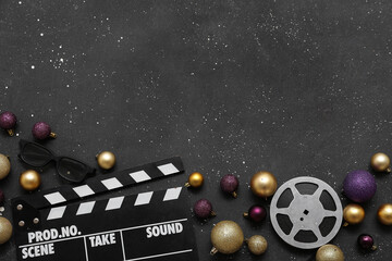 Composition with movie clapper, 3D glasses, film reel and Christmas decorations on black...