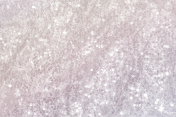 Shiny pearlescent festive background with sequins.