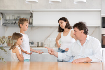 Obraz premium Parents, father and mother, scolding little son and daughter for disobedience