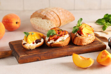 Wooden board of peach bruschetta with ricotta and mint on white table