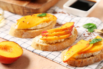 Peach bruschetta with ricotta, flax seeds and basil on beige background, closeup