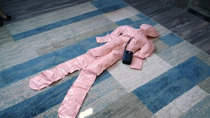 A time lapse view inflating a life-sized blow-up doll on a living room floor.  	