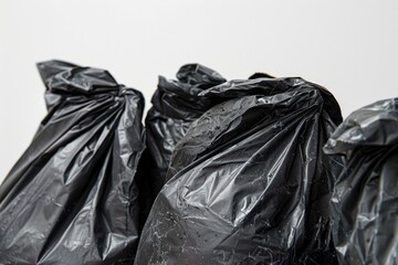 A collection of black bags arranged neatly on a table, suitable for use in scenarios such as storage, shipping, or packaging
