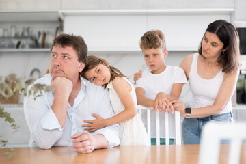 Upset family with son and daughter arguing in kitchen at home