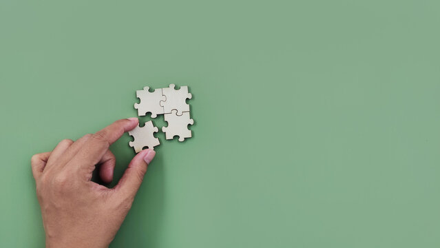 hand holding wooden puzzle. partnership, connection and teamwork concept