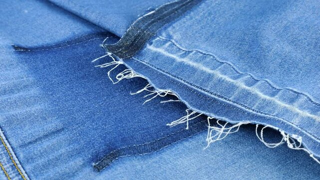 Soft folds of bright light blue denim fabric rotate on the showcase. Textile background on the theme of reuse, recycling clothing and textile for the purpose of preserving the environment. 