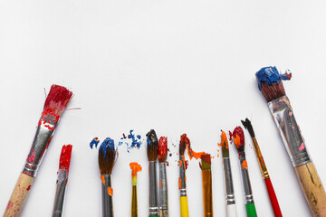 Artist brushes with paints on grey background