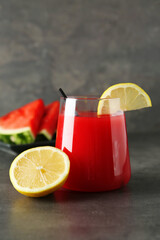 Delicious watermelon drink in glass and fresh fruits on dark grey table