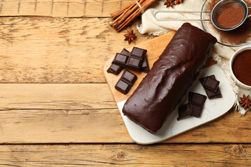 Tasty chocolate sponge cake and ingredients on wooden table, top view. Space for text