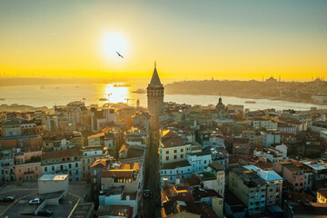 Galata Tower. A close-up photo of the Galata Tower, one of the few beauties of Istanbul, taken with a drone at sunrise. The magnificent view of the sea and buildings in the background.