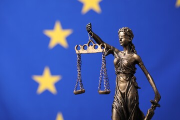 Figure of Lady Justice against European Union flag. Space for text