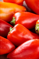 Fresh Ripe Red and Orange Bell Peppers on Brown Clay Surface, Vibrant Vegetables