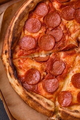 Pepperoni pizza with sausage, mozzarella cheese, tomatoes, salt and spices