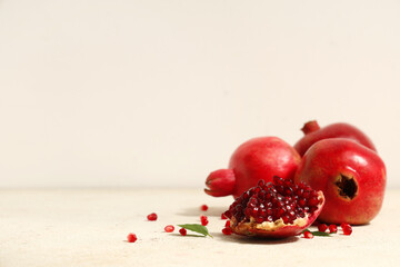 Fresh ripe pomegranates with seeds and leaves on white background