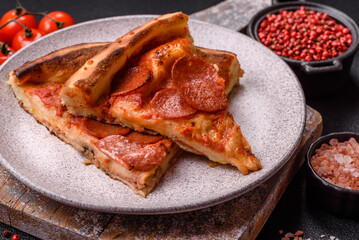 Pepperoni pizza with sausage, mozzarella cheese, tomatoes, salt and spices