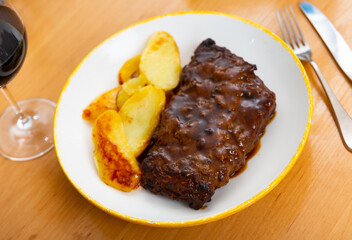Appetizing american style fried pork ribs served with potatoes