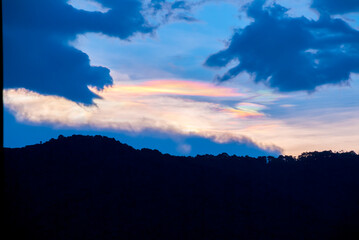 Silhouette of mountains with multi-color lenticular clouds in rural area of Guatemala, city of Latin America, sunset landscape.