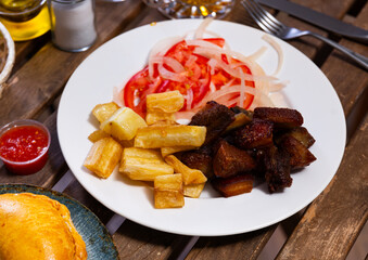 Delicious braised chicharron with fried yuca and fresh salad for snack
