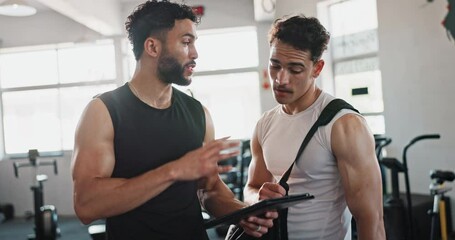 Coaching, tablet and personal trainer with people in gym for training, exercise schedule and fitness. Bodybuilder, strong and sports athlete with person and planning for energy, wellness and team