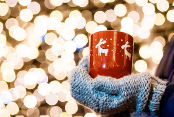 woman holding mug with mulled wine at christmas market