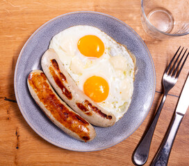 Appetizing fried eggs with sausage served on plate for breakfast