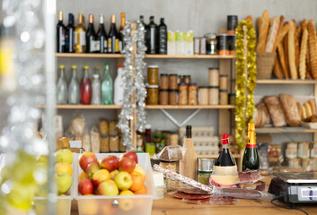 Appetizing variety of food products and bottles of wine on a store counter during Christmas celebration