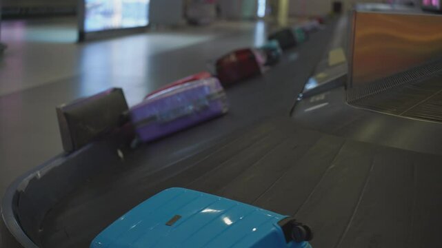 Luggage claim carousel rotating with suitcases at an airport, illustrating the baggage retrieval process for travelers