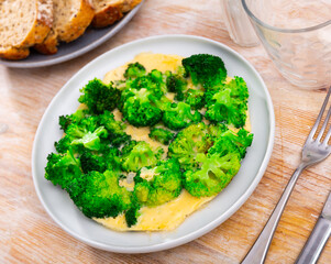 Appetizing omelet with fresh broccoli served on plate for breakfast