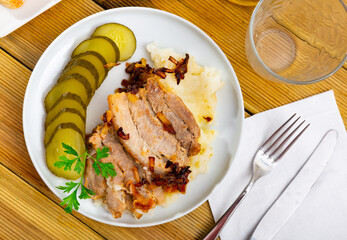 Delicious pork steak served with potatoes and pickles. Festive dinner
