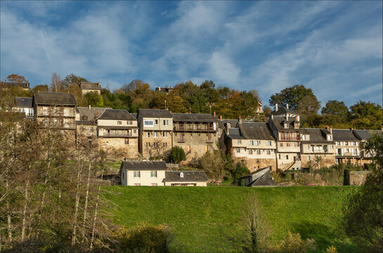 Looking upwards at rows of typical French houses om a hillside against a beautiful blue sky
