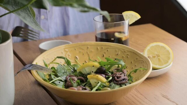 Fresh Octopus Salad with Herbs and Vinaigrette Mediterranean Culinary Delight. A vibrant Mediterranean-style octopus salad, prepared with fresh herbs, greens, and a zesty vinaigrette dressing