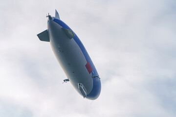 Fototapeta premium An airship in the sky with people on an excursion above the earth in a tourist flight.