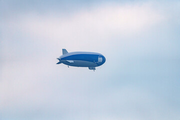 An airship in the sky with people on an excursion above the earth in a tourist flight.